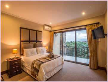 Another view of the main bedroom of the Baluwatu unit at Zimbali Holiday Home, showing it's air conditoner and HD TV